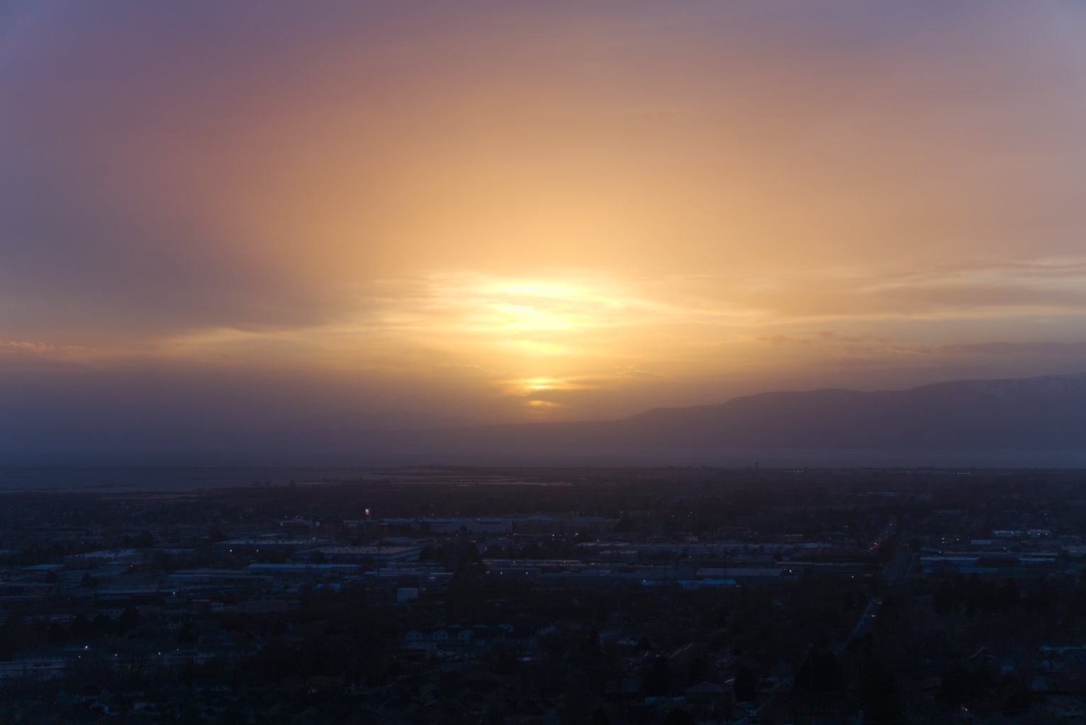 The sun sets and casts a peculiar kind of glow on a hazy evening