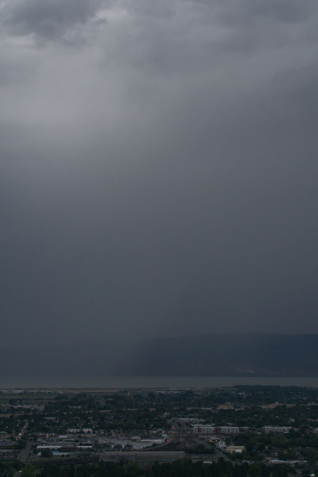 A sheet of rain falling over Utah Lake and town