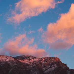 Sunset lit clouds drift of a mountain top