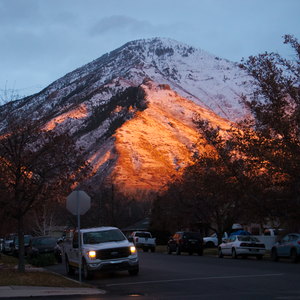 The mountains flush red with sunset light over a neighborhood