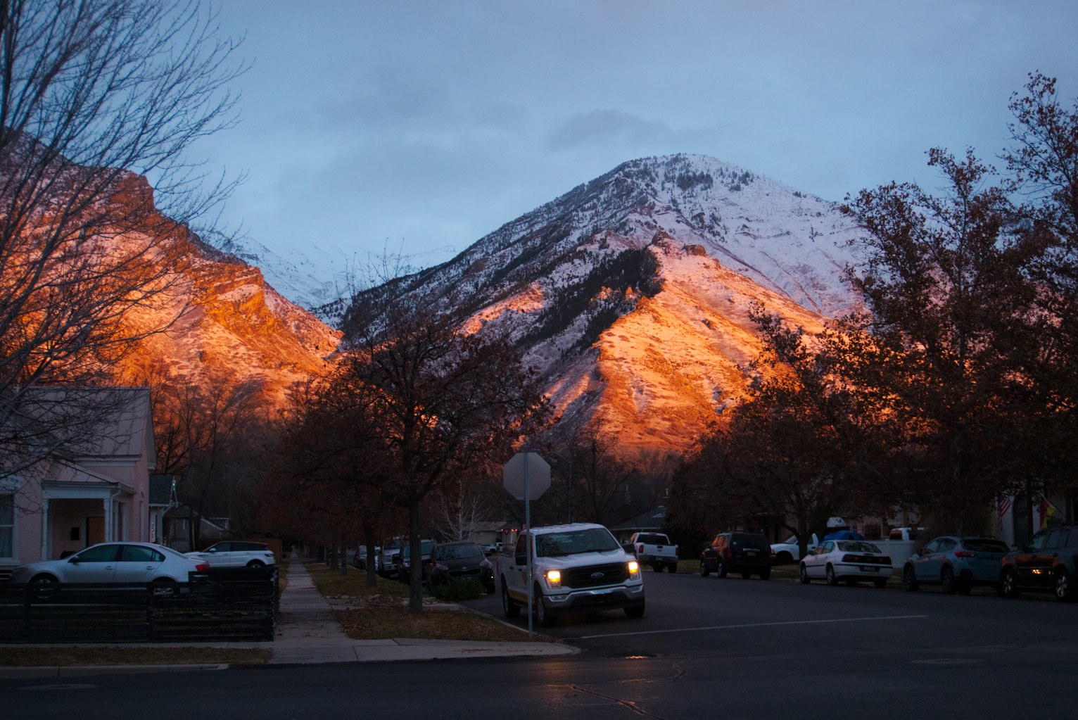 The mountains flush red with sunset light over a neighborhood