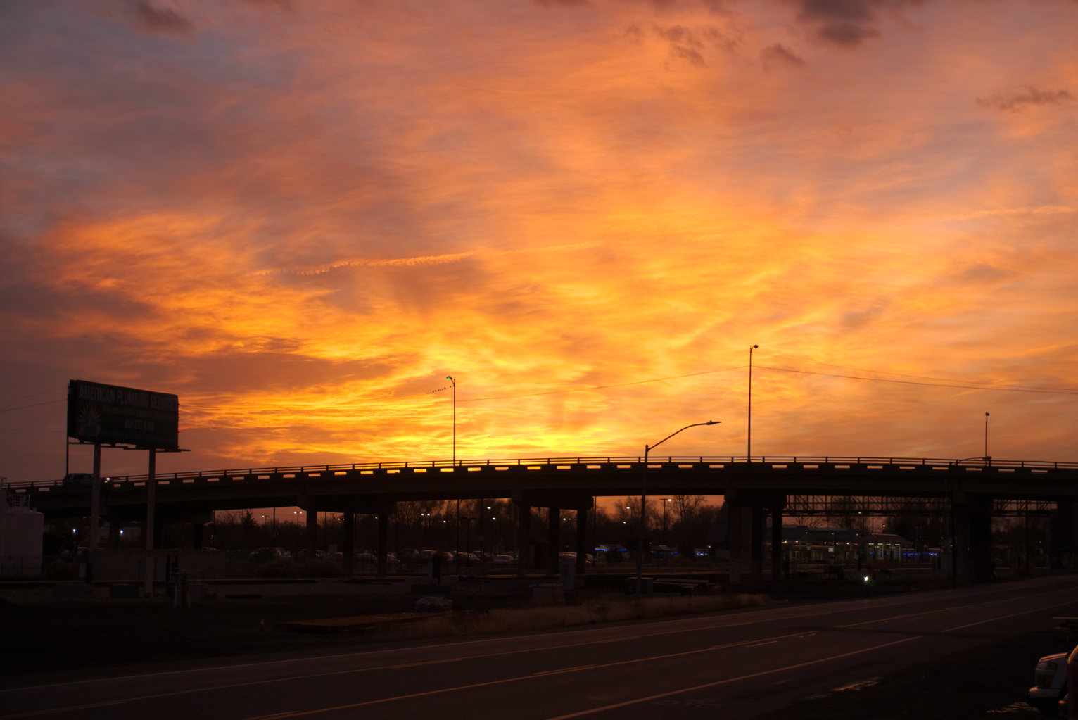Sunset burns bright above an overpass