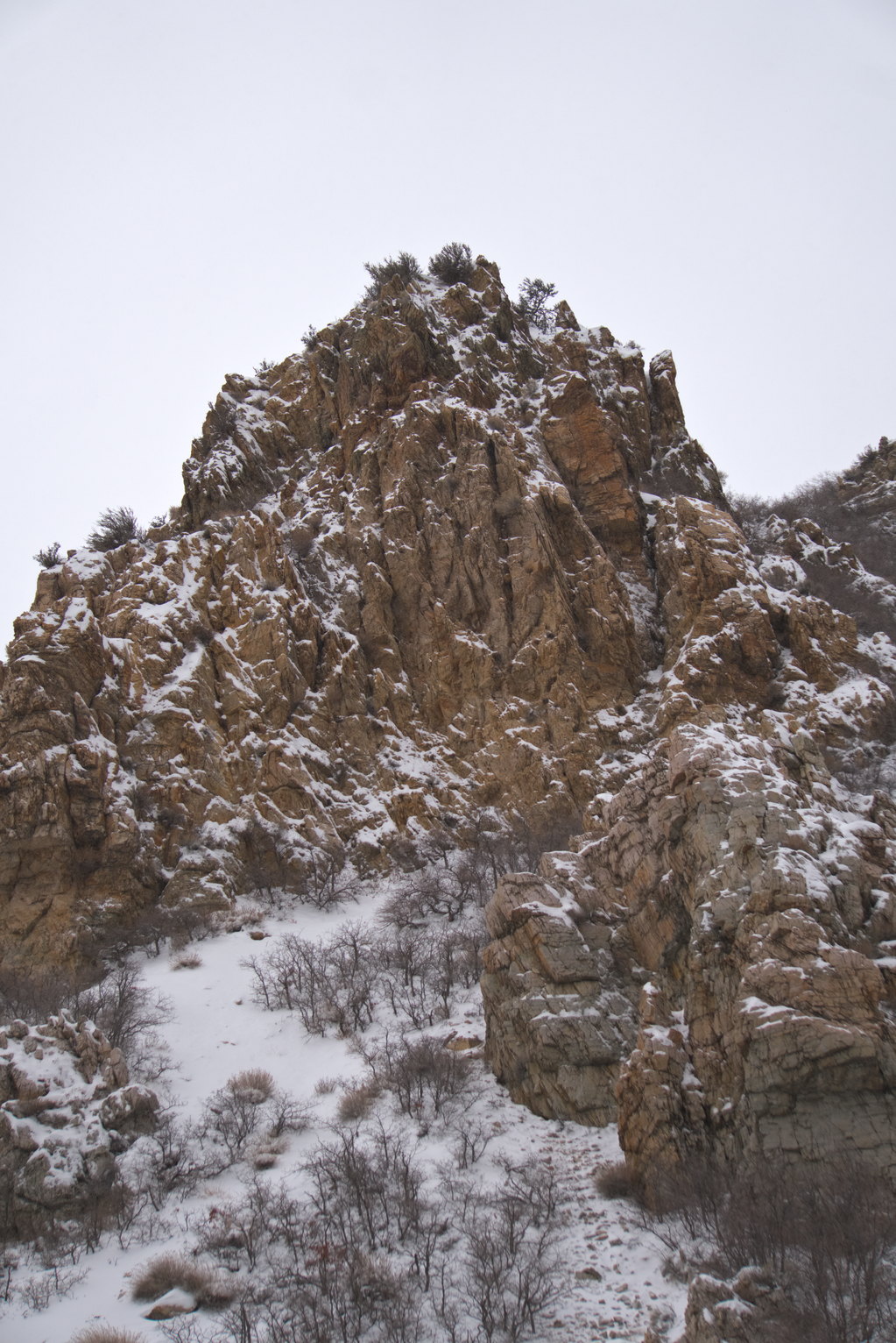 A rocky outcrop on the mountain side highlighted with snowfall