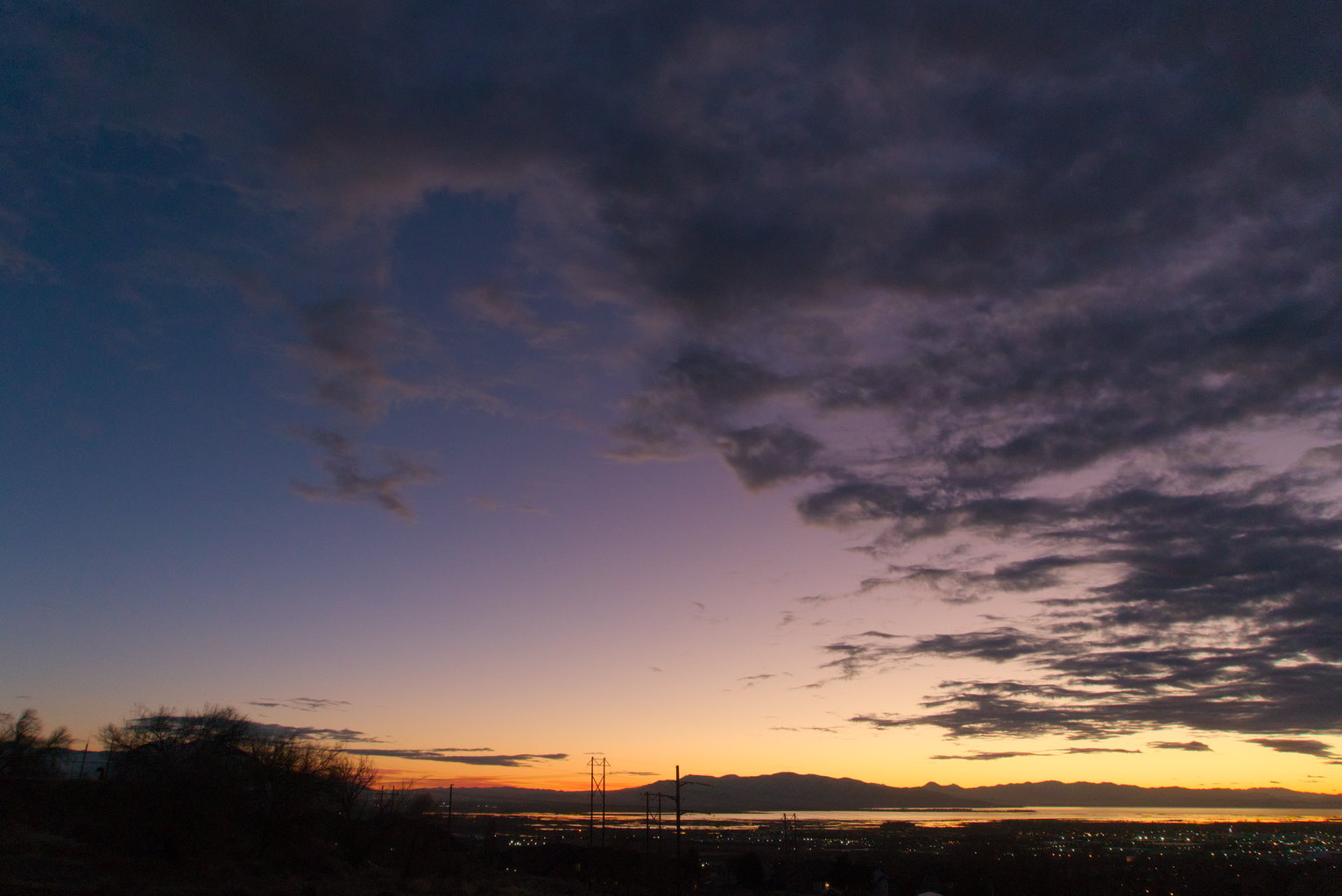 Evening yellow to purple to blue sky with some grey clouds.