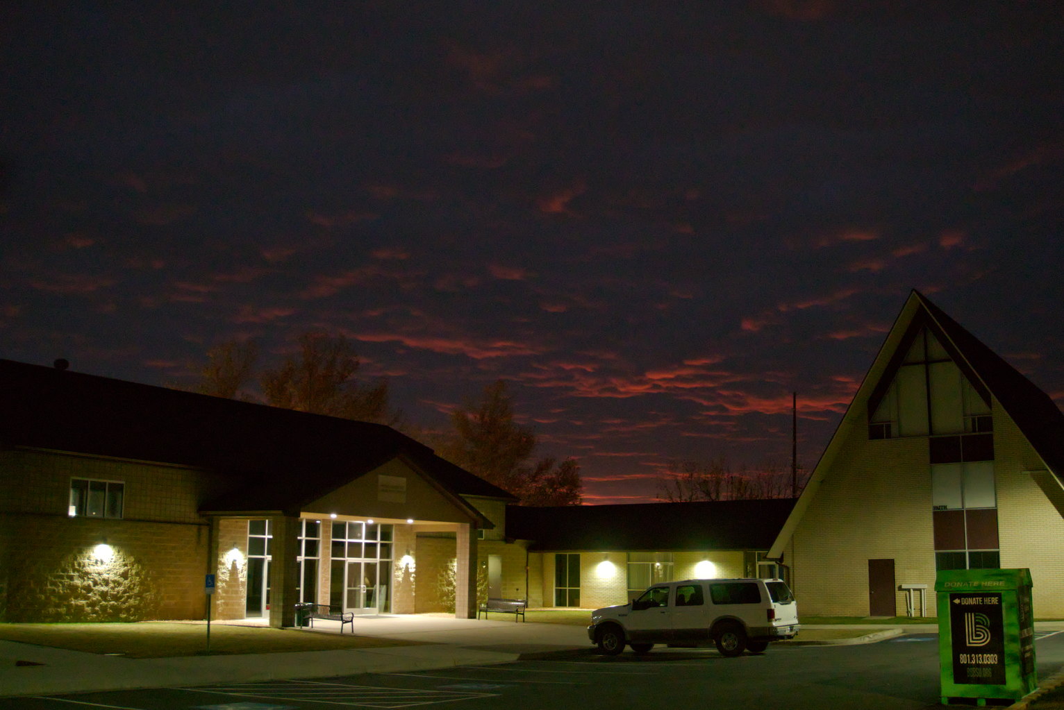 In the night clouds still catch some of the orange glow of sunset over a church.