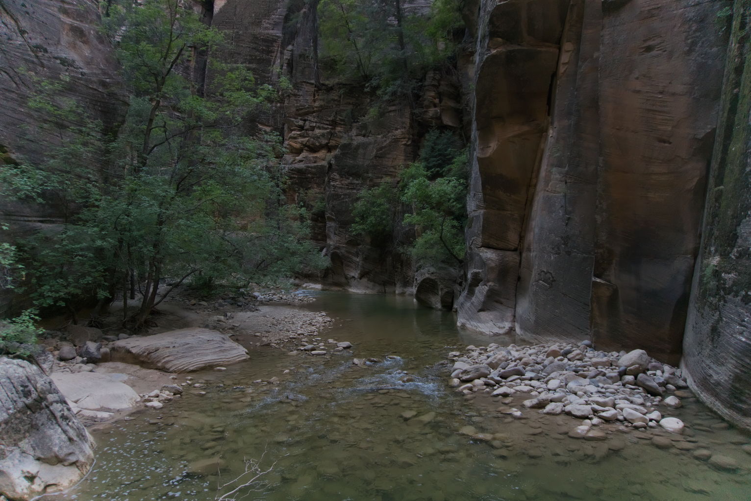 Walls of rock on either side of the river, some trees