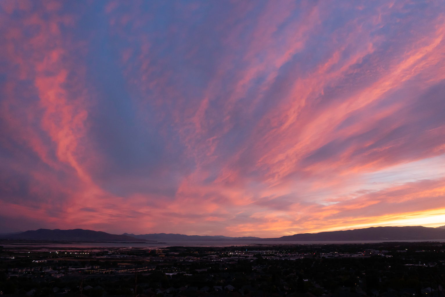 Sunset lit clouds stretch out over town and the mountains to the west.